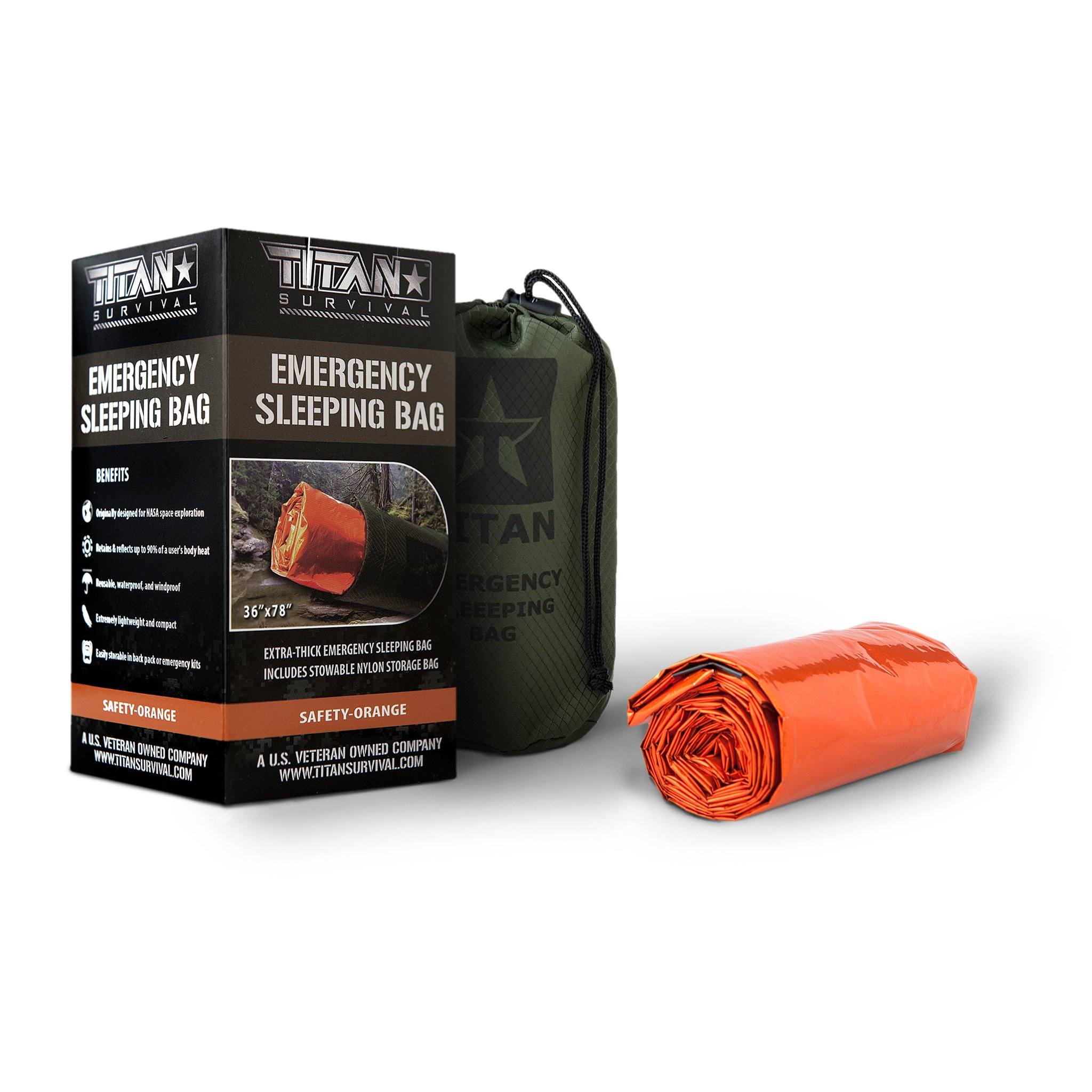 Survival orange colored, rolled up, sleeping bag next to a car case product box on a white background
